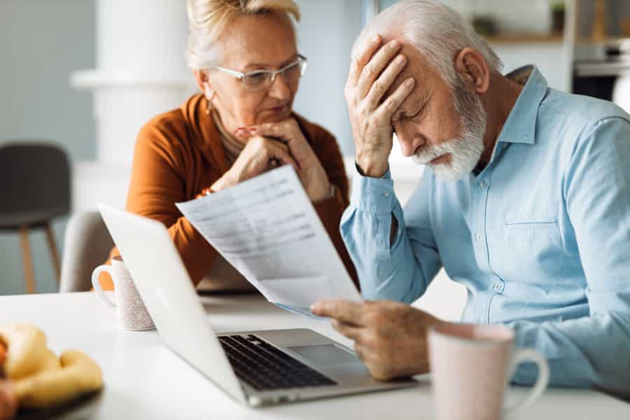 Two people looking at the document and a laptop