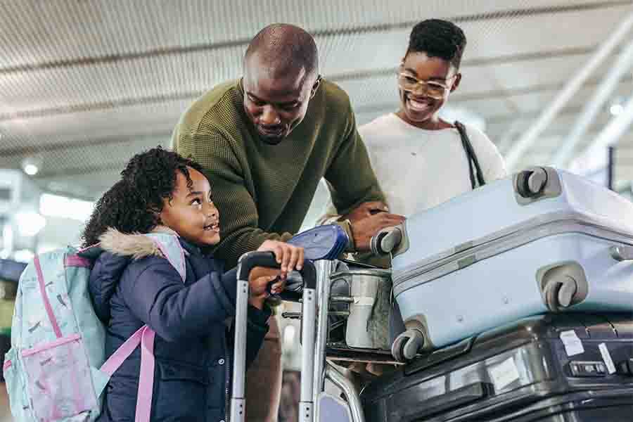 A family consisting of a mother, father, and their young child engaged in conversation at the airport