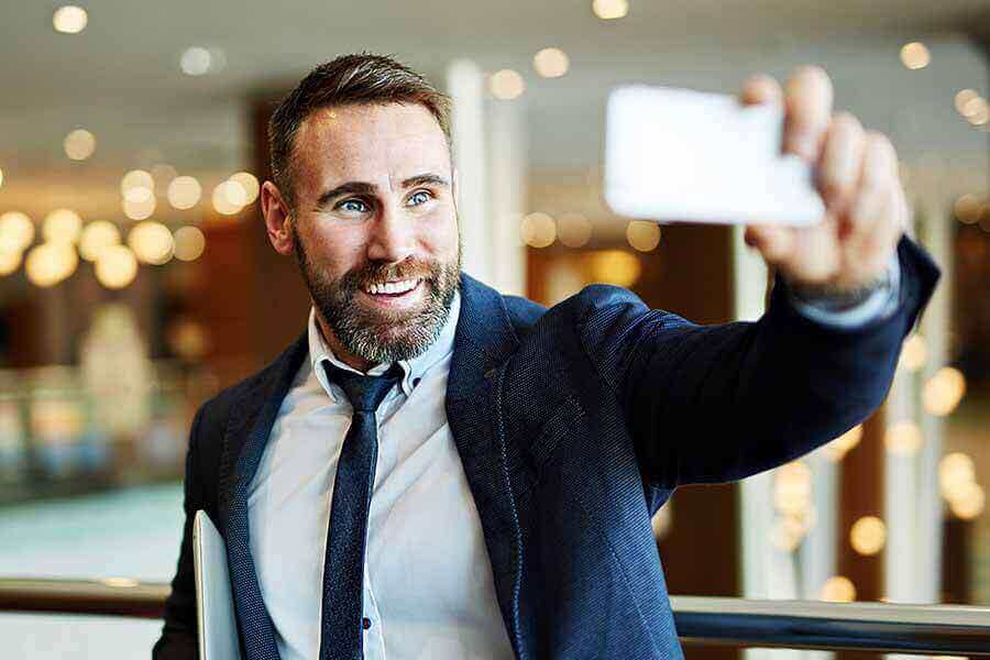 A person attempting to take a selfie with phone camera outstretched.