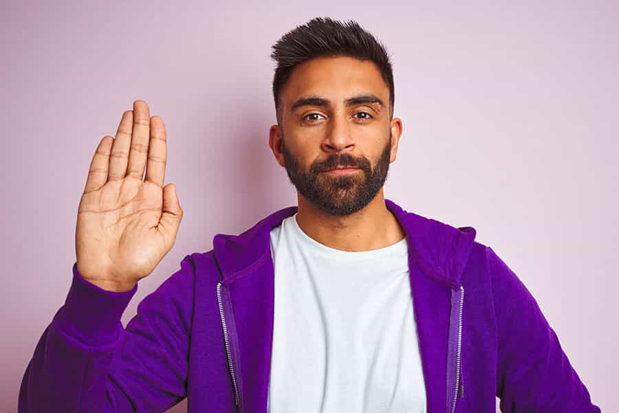 A person lifting right hand to swear an oath