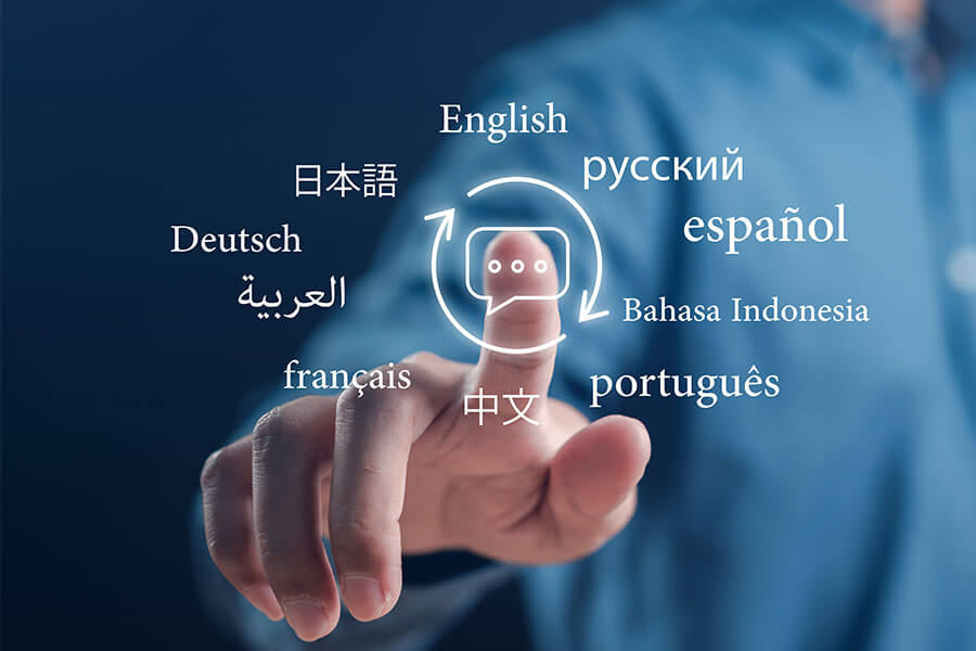 A hand hovering a finger over a chat icon with symbols for different languages