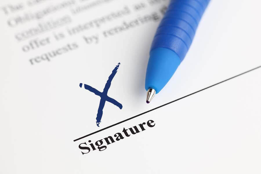 A document with a signature in the shape of an X at the bottom left corner.