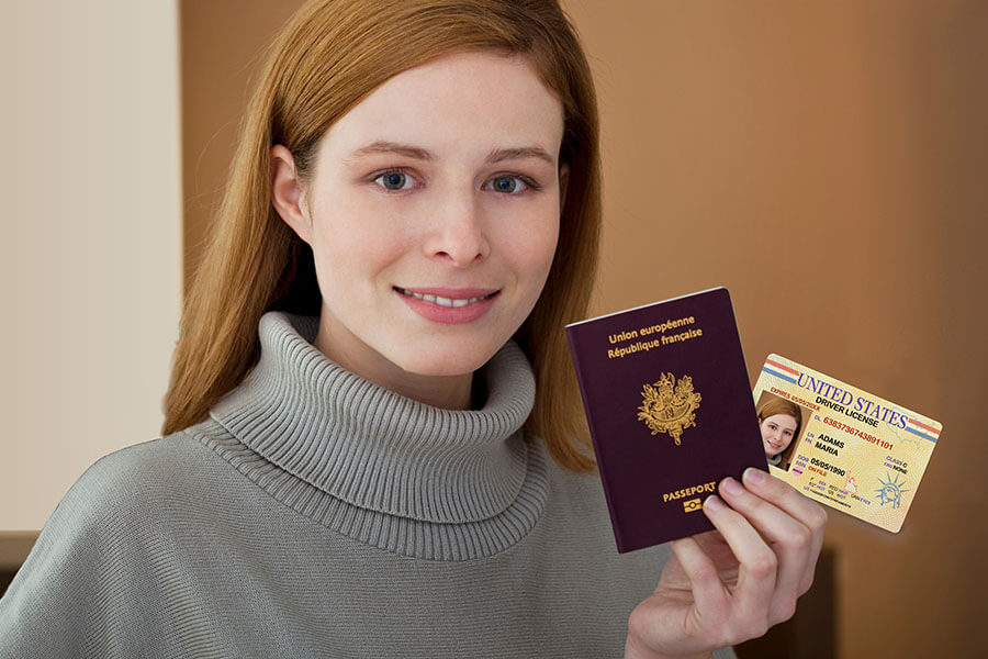 A person holding a passport and an ID card