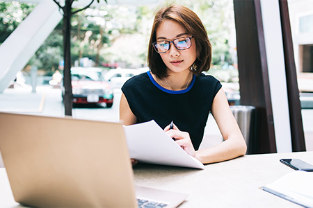 Woman wearing glasses working on a laptop