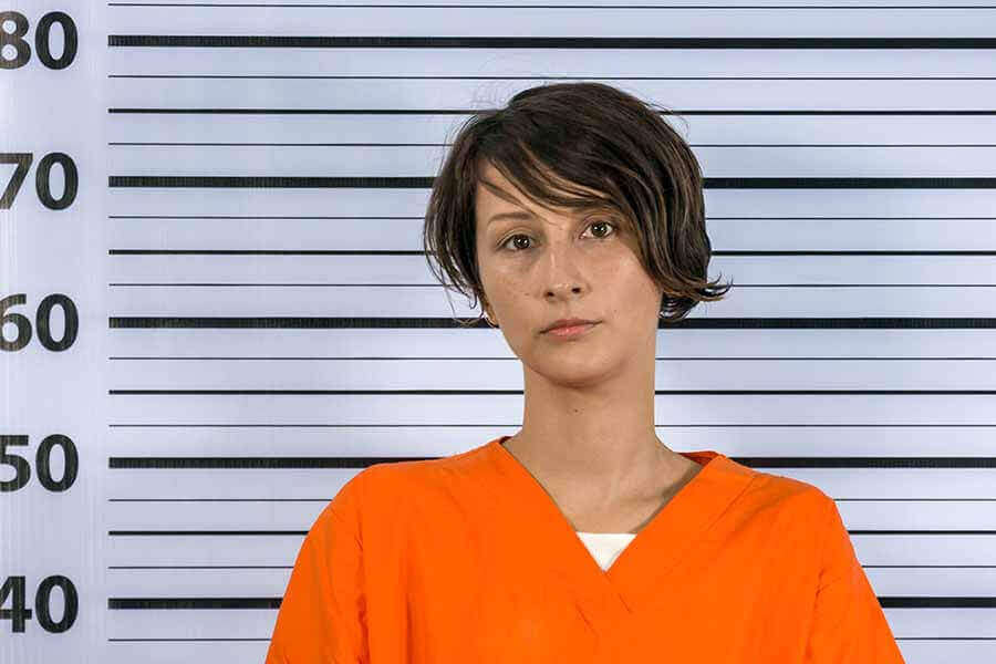 a mugshot of a woman wearing an orange jumpsuit