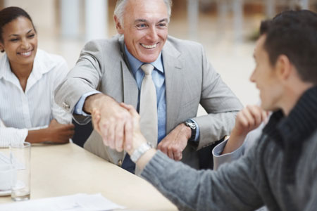 Two men in business suits shaking hands