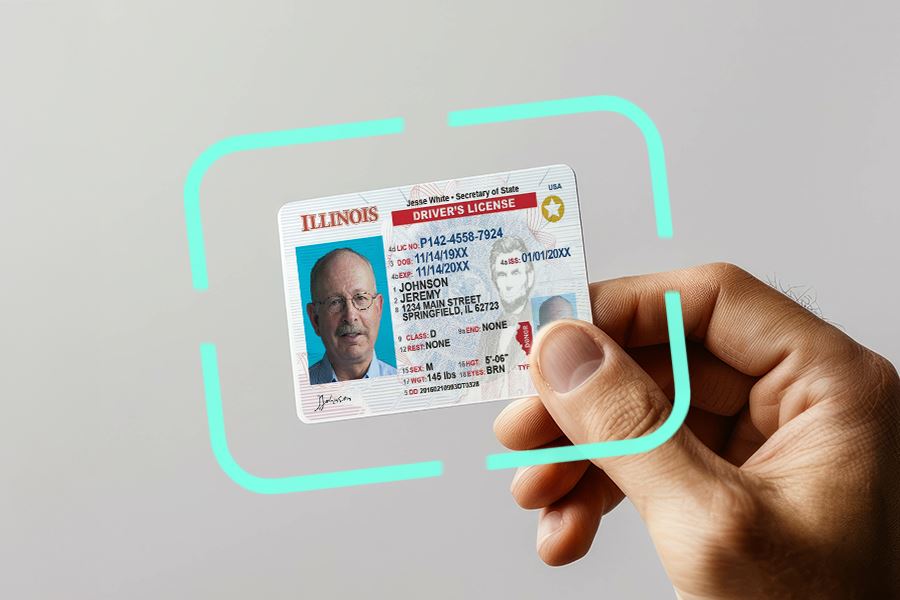 Male hand holding a driver's license of an Illinois resident