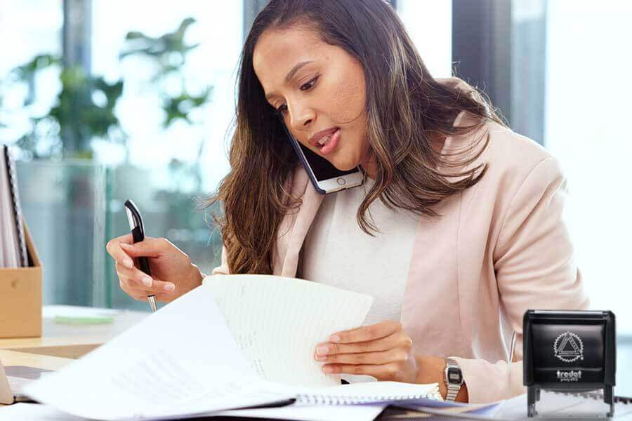 A person on the phone reviewing a document