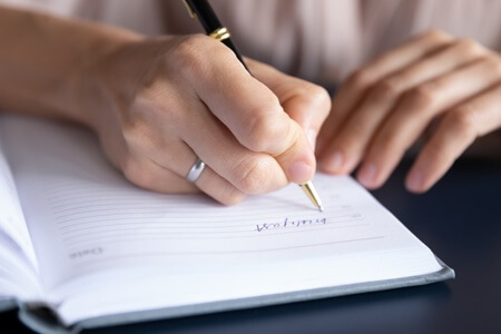 Female hand writing in journal