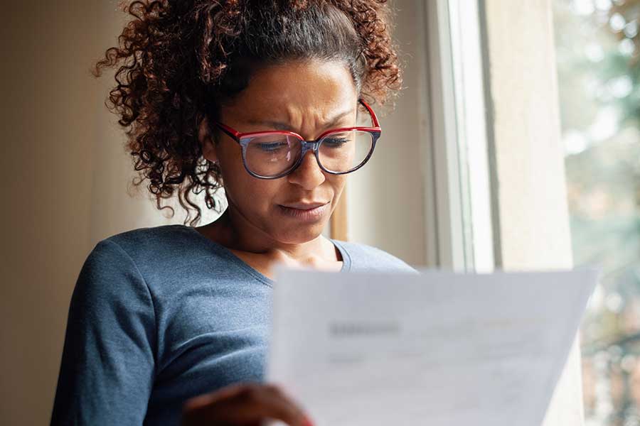 woman with a serious expression looking at an invoice