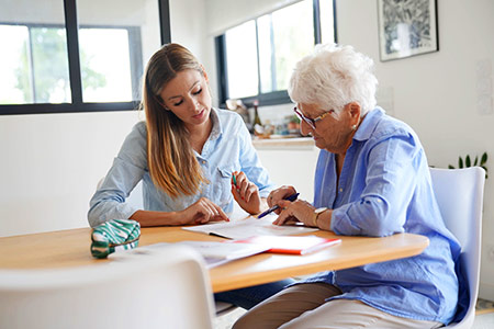 Young person and elderly person discussing a document in a cozy living room.