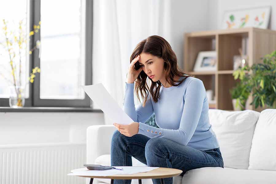 A person with a concerned expression sitting on a couch