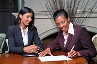 A woman signing a document in the presence of a Notary