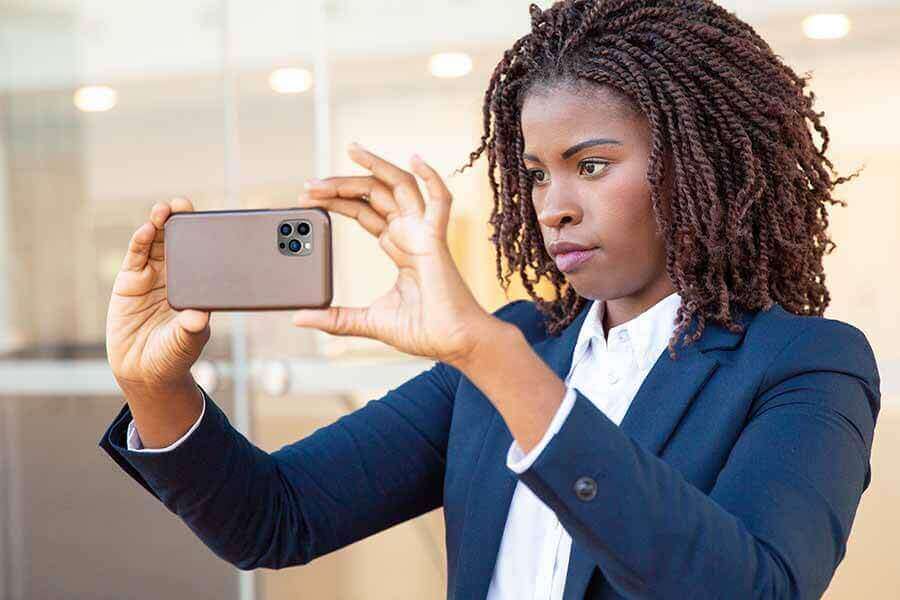 A person holding up a smartphone horizontally to take a picture.