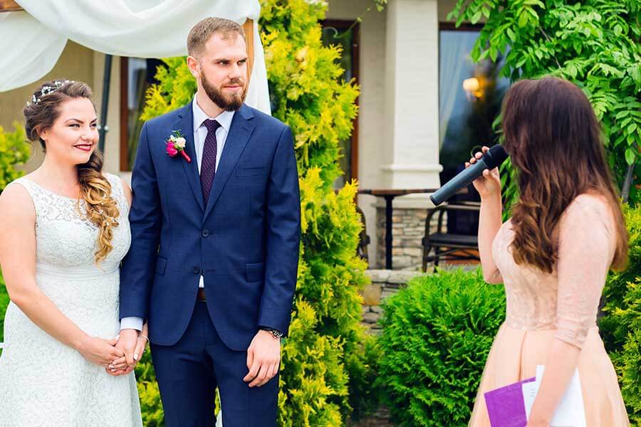 A couple standing with an officiant on their wedding day