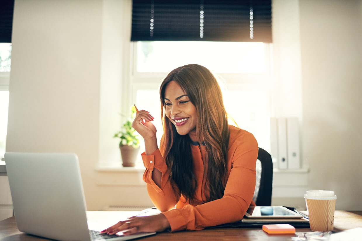 Work-from-home Notary at laptop smiling