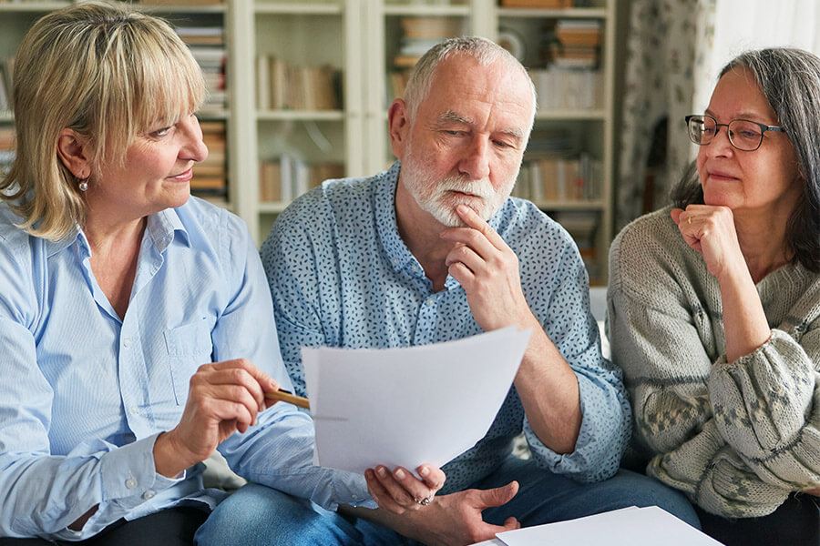 An elderly couple appearing concerned with a notary present.