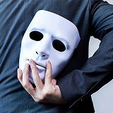 A person holding a mask hebind his back