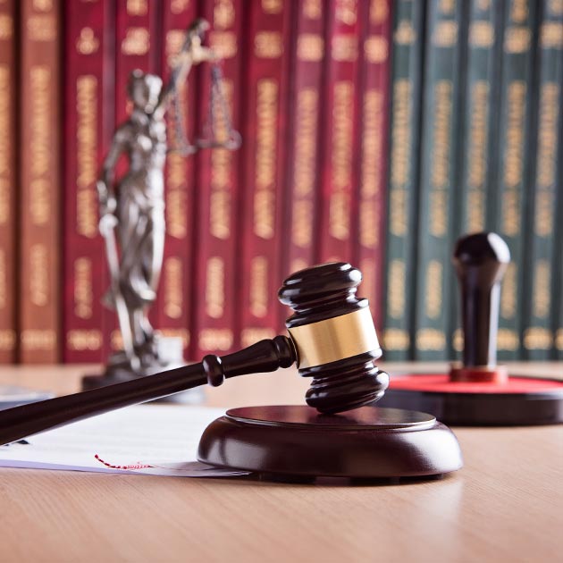 Wooden gavel on desk with bookshelf in the background