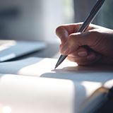 A person writing down on a journal