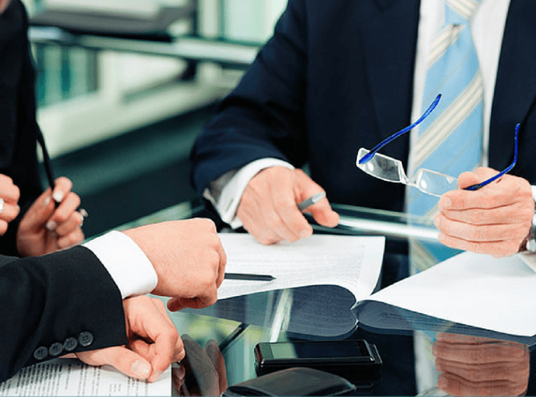 Two people in suits reviewing a document