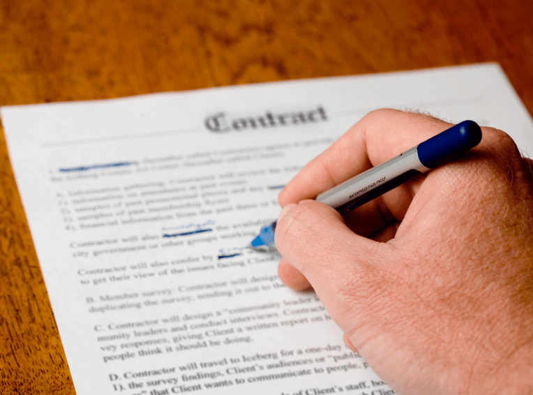 Hand holding a pen and marking a document