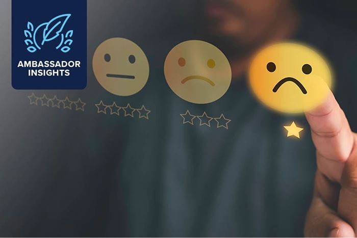 Hand selecting a frowning face rating icon.