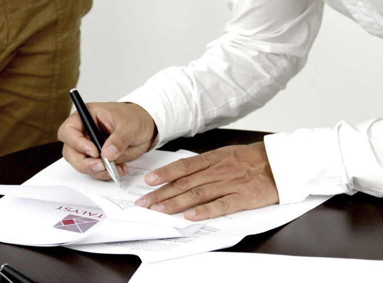 Hands signing a document