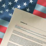 A U.S. flag beside a stack of documents.