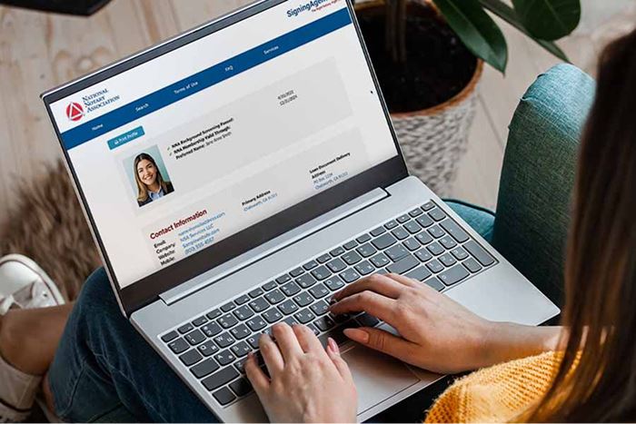 Person viewing a SigningAgent.com profile on a laptop.