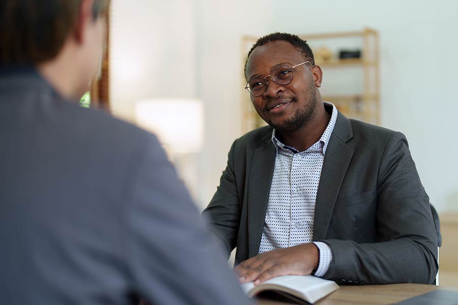 Seated man in glasses and business attire looking at a Notary